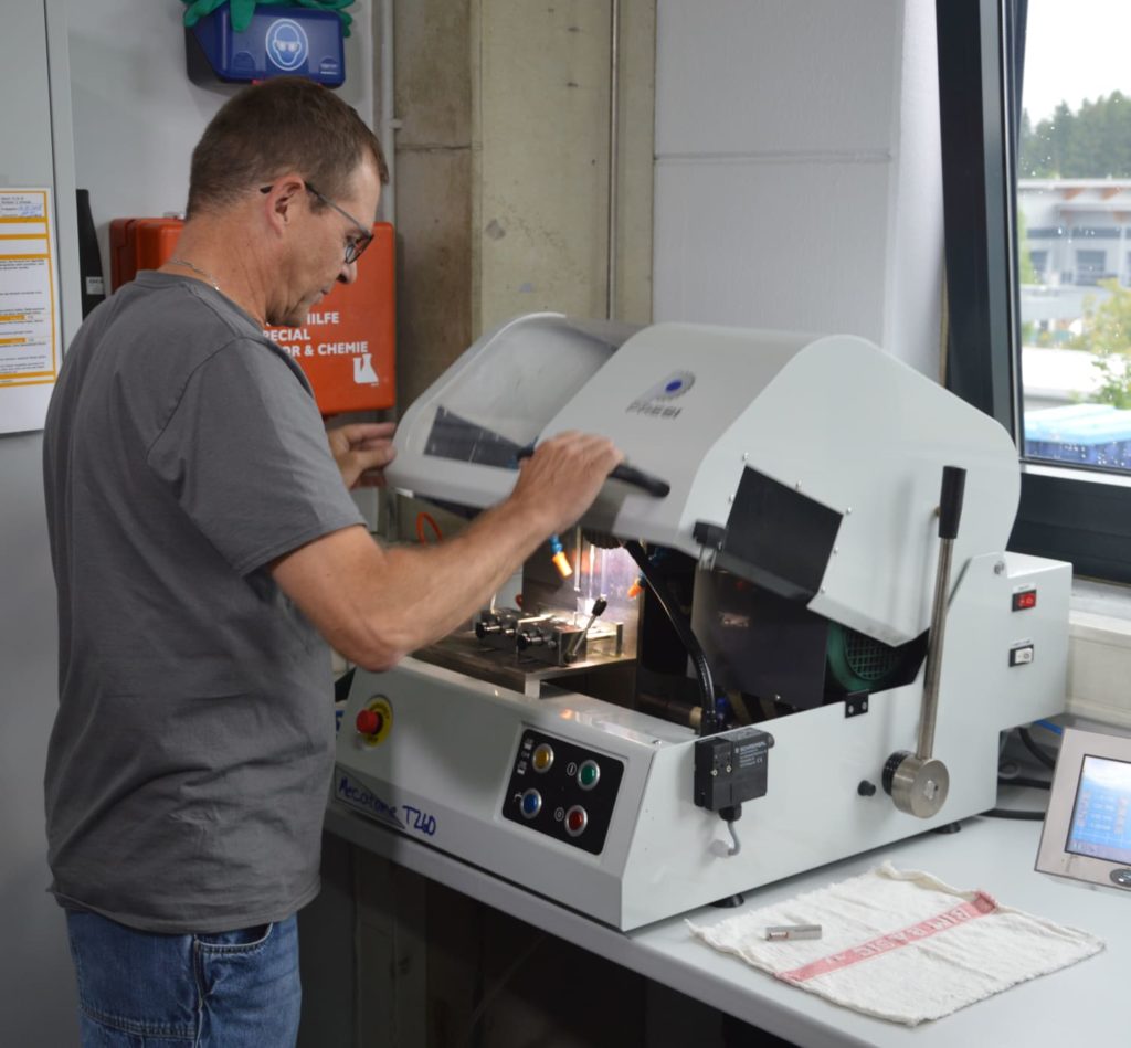 Ein Mitarbeiter arbeitet an einer modernen Maschine zur Qualitätsicherung von BURKHARD Sprühköpfen in einer Werkstatt
